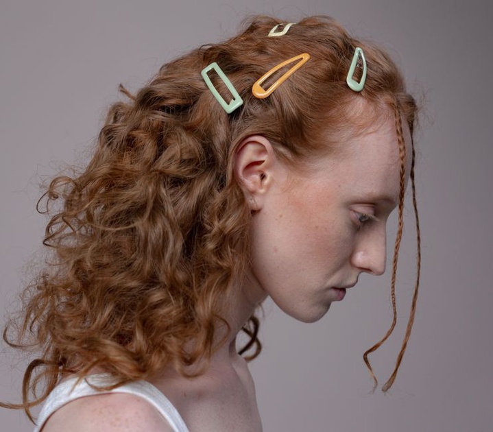 Three vintage resin hair slides in muted 1950s tones arranged on a white background