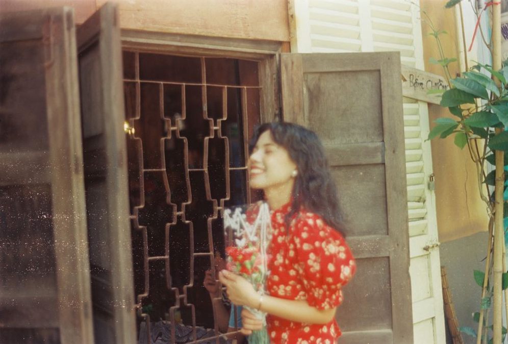Woman in a floral maxi dress with a carved wooden comb swept into her hair, 1970s style