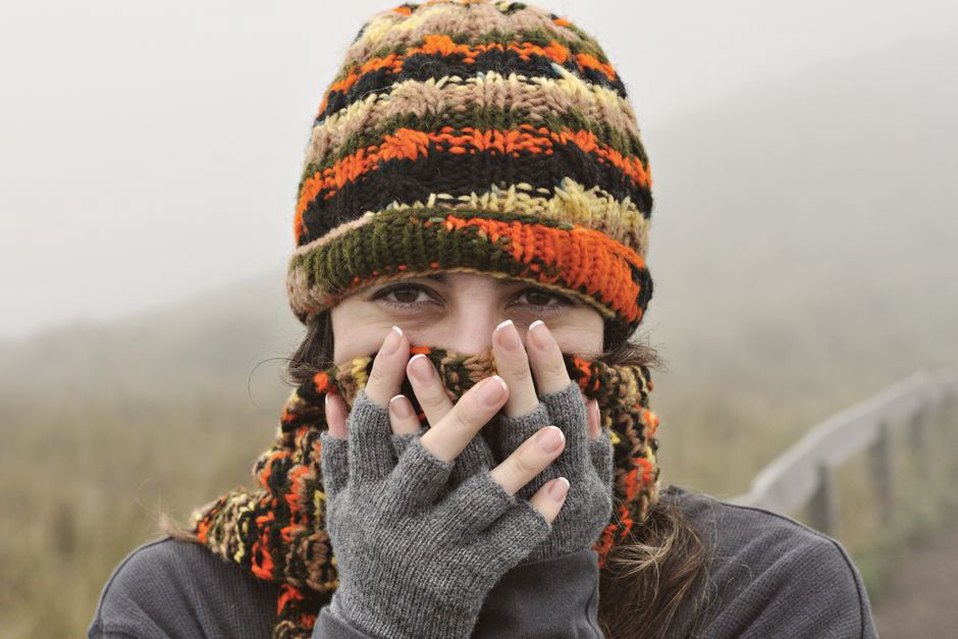Woman in a 1970s-inspired knit headband and snood set in warm autumnal tones