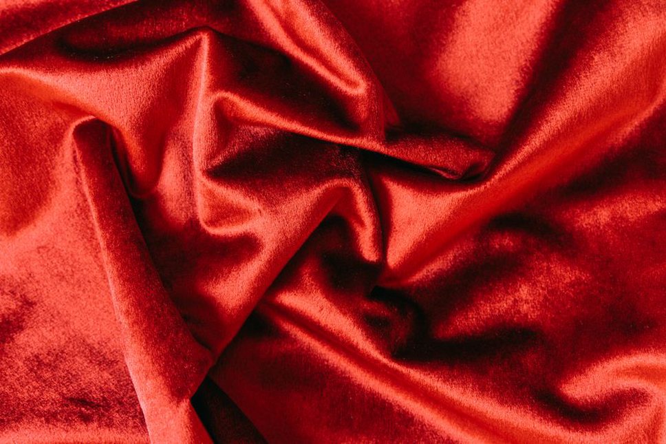 Close-up of a ruched velvet scrunchie with a small bow at the seam
