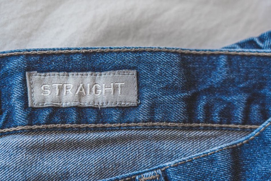 White woven label with black text inside a vintage dress collar