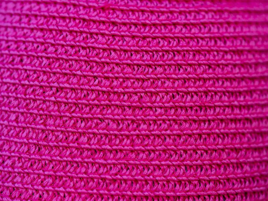 Detail of tight double crochet stitches and hand-sewn band on a red beret