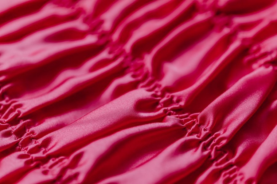 Detail of a black satin headband showing neat French seams and a padded front panel