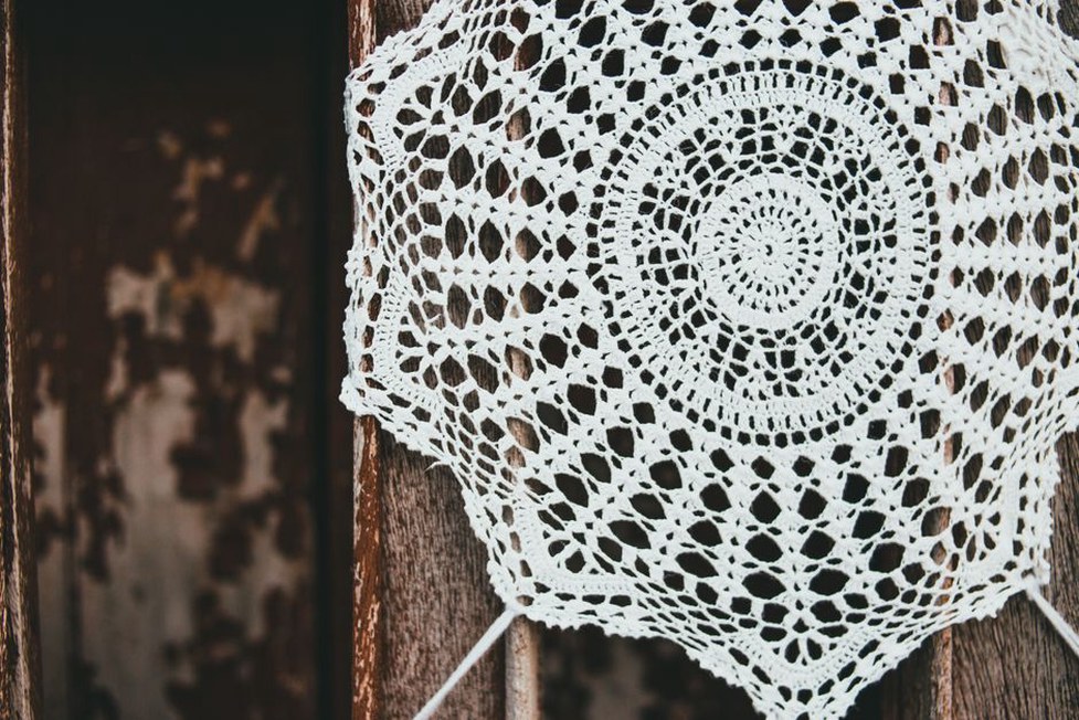 Vintage cream crochet cap with intricate lace stitches and scalloped border
