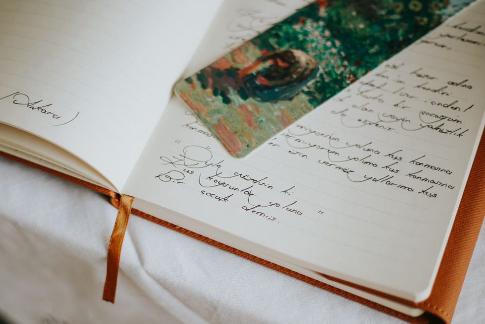 a vintage comb resting on a page of handwritten collector notes beside a laptop