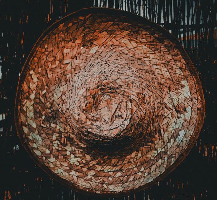 Close-up of woven straw headband showing label and hand-stitching