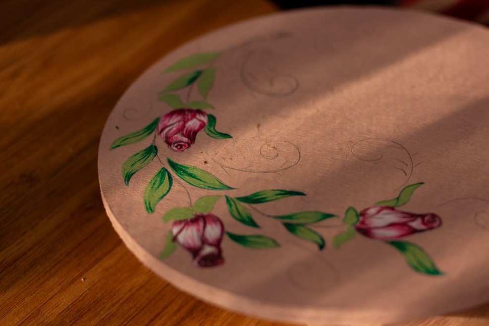 Hand-painted Millie Green hair claw resting on dark velvet