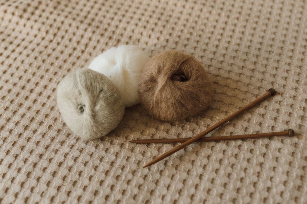Close-up of a creamy alpaca wool hair band showing cable-knit pattern