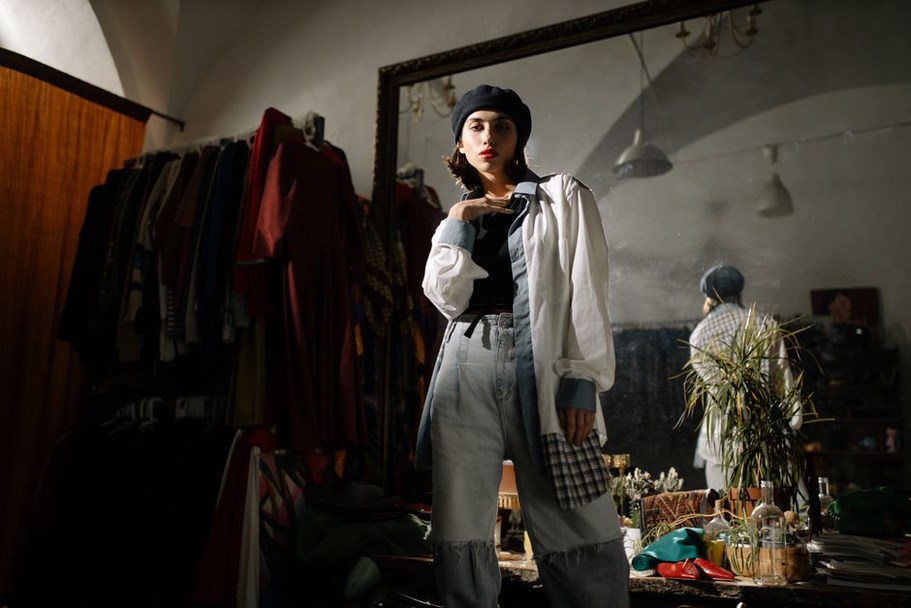 Woman in beige trench coat wearing a blue snake beret and jeans