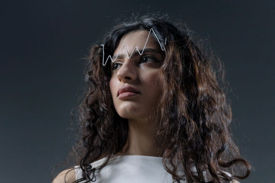 Close-up of a vintage hair clip shaped like a melting clock, with gold-toned metal and cream resin