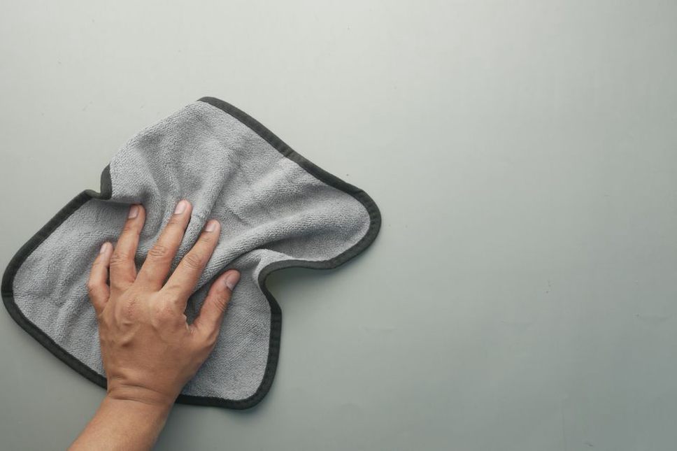 Close-up of a hand cleaning a tortoiseshell star hair accessory with a microfiber cloth
