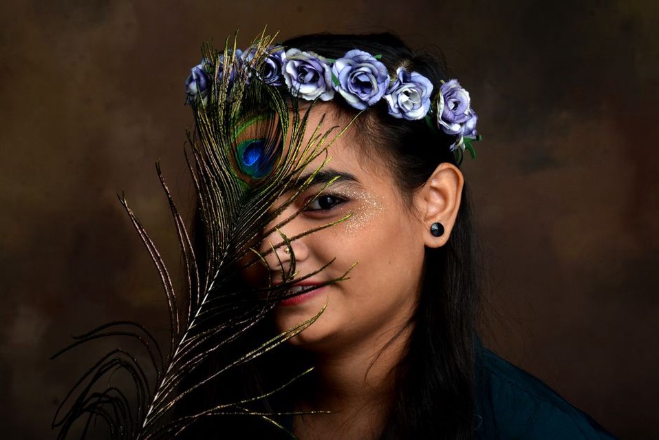 Blue silk rose crown headband resting on dark velvet with seed pearl centres