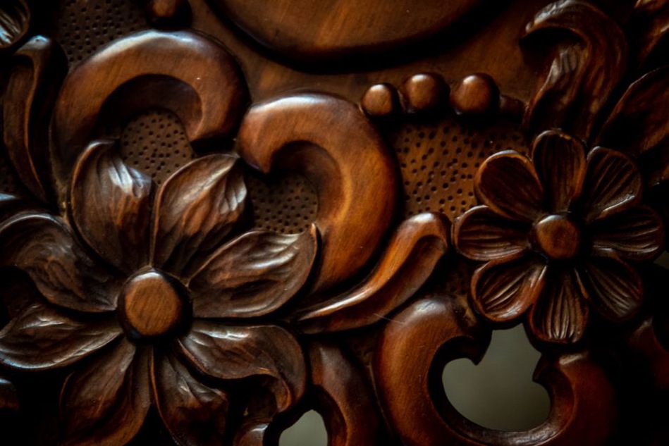 Edwardian carved horn comb with floral motif on a wooden surface