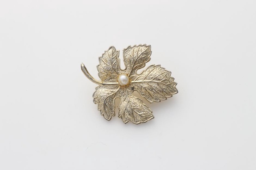 Close-up of a green enamel leaf hairclip with veined details