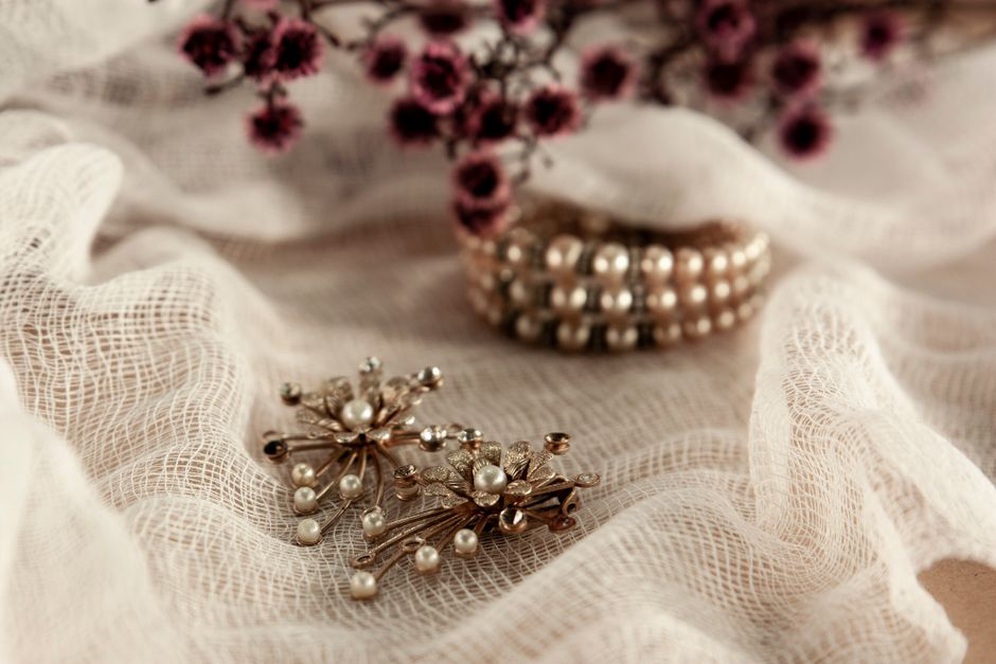 Close-up of a gold-tone barrette with a cluster of creamy pearls on a dark background