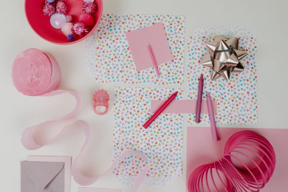 A pink resin bow barrette resting on its original vintage card, showing the brand name and cut-out display