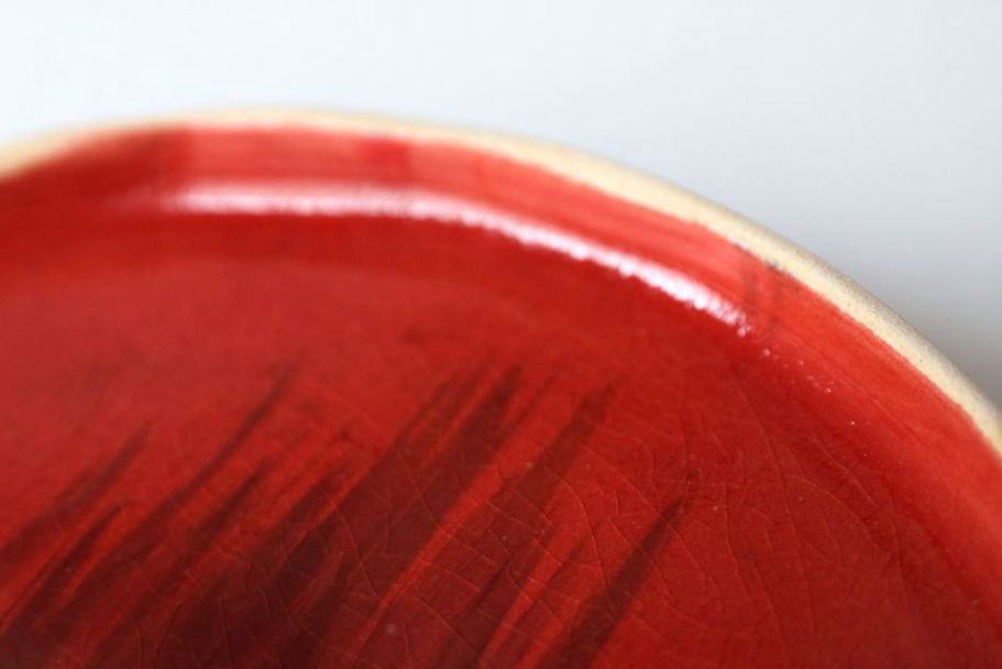 Ruby cellulose acetate hair clip resting on a white ceramic dish
