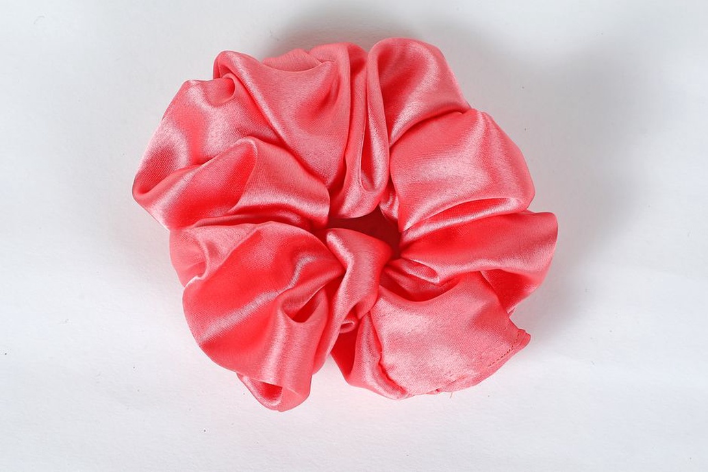 A generous ivory silk scrunchie resting on a vintage dress form