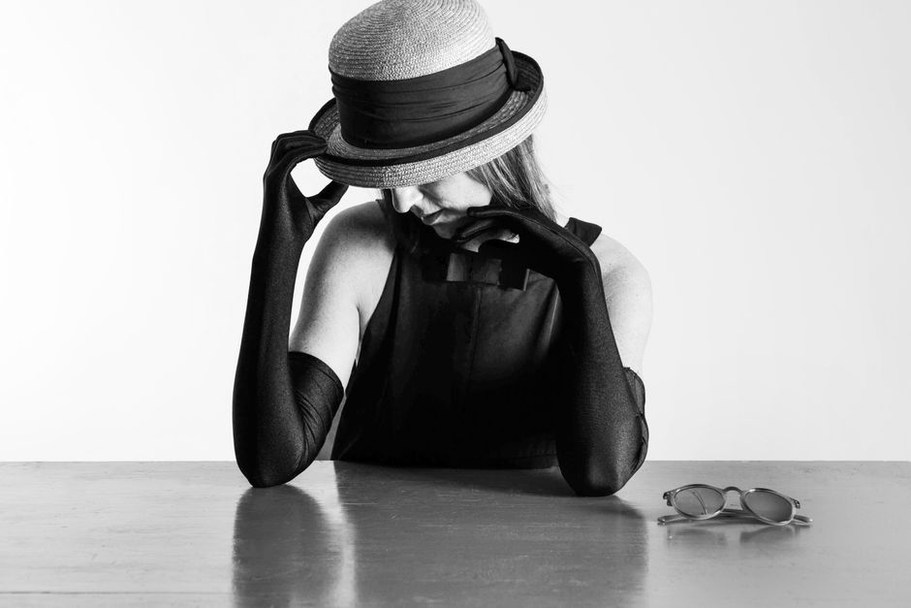 straw cone hat displayed on a vintage millinery stand