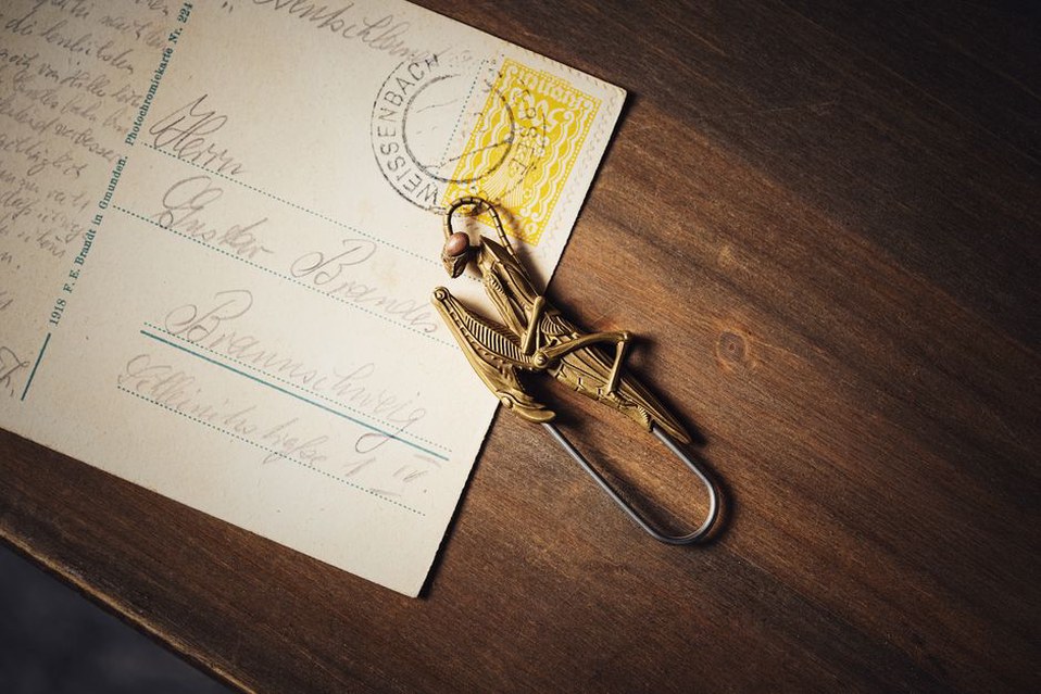 Amber Edith clip resting beside a leather notebook