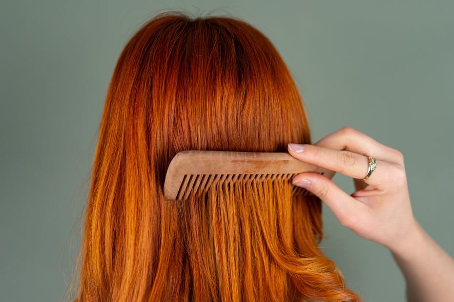 Woman positioning a carved tortoiseshell comb in soft waves