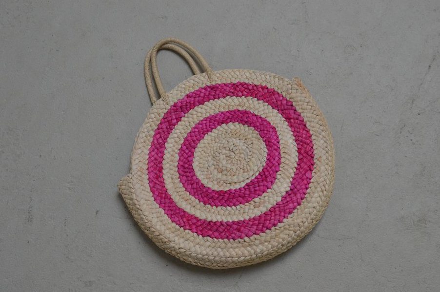 Antique wicker handbag filled with colourful vintage hair barrettes