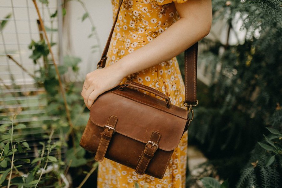 Woman in floral dress holding a woven wicker bag