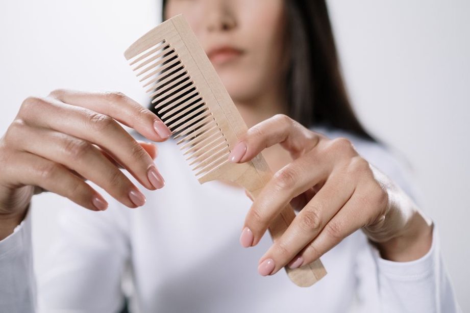 woman examining a vintage tortoiseshell comb with care