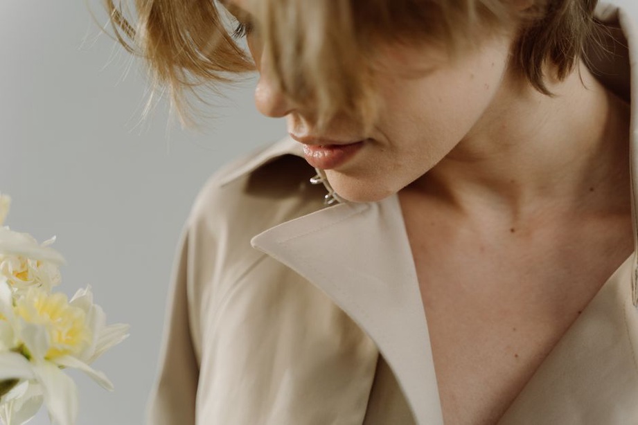 Low chignon secured with champagne hair claw, worn with a classic trench coat