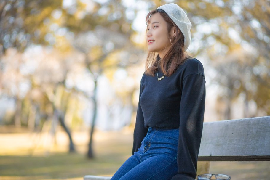 woman styling a vintage orange beret with daisy motif in a casual spring outfit
