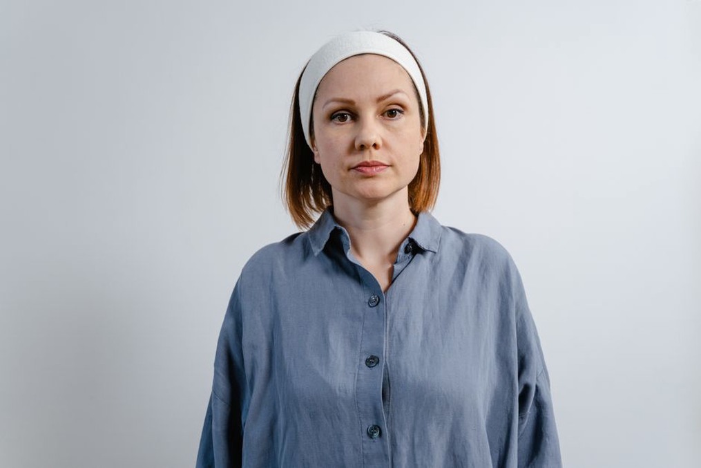 Woman wearing a navy velvet turban headband with a white blouse