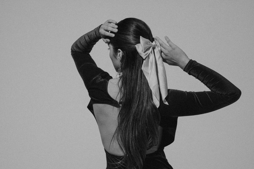 Velvet bow pinned in soft waves evoking 1950s British elegance