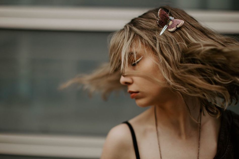 Crescent moon clip holding a half-up hairstyle with a cream blazer and gold earrings