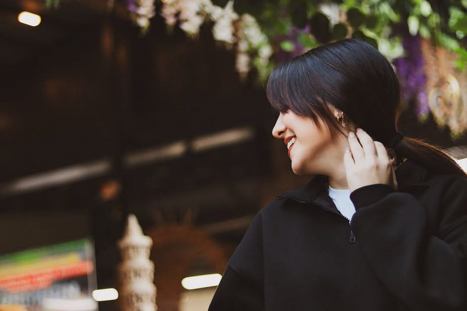 Low ponytail styled with aubergine velvet scrunchie and neutral outfit