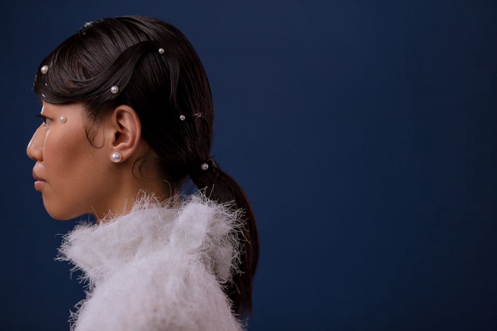 Half-up hairstyle accented with a blue pearl bow barrette