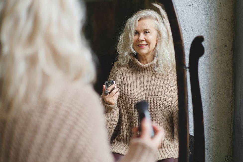 Woman styling a grey enamel barrette with a cream jumper and loose waves
