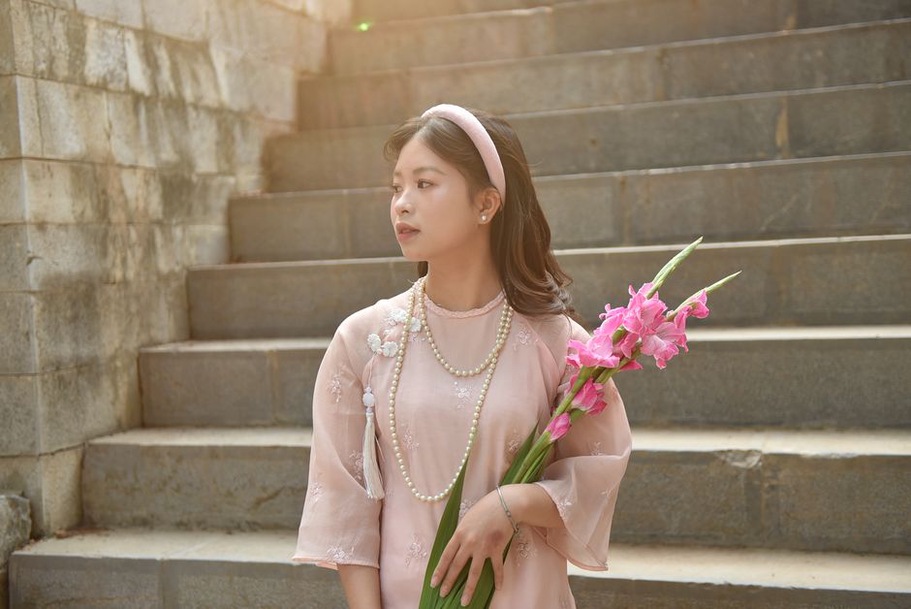 A woman in a mod-style dress and hot pink squared headband