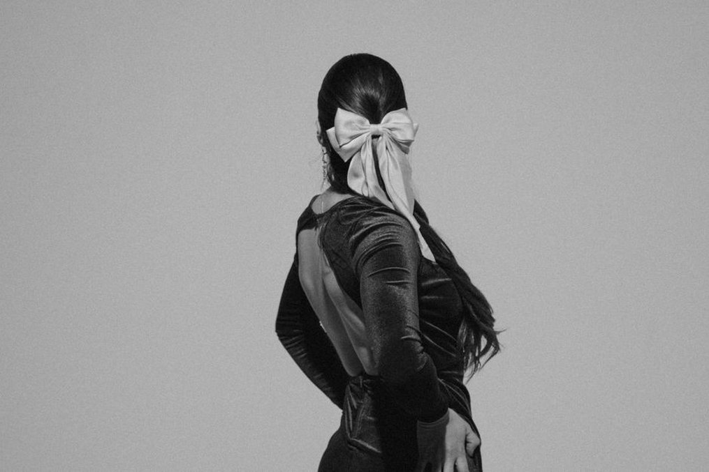 A velvet hair bow pinned at the nape of the neck, inspired by 1940s utility fashion