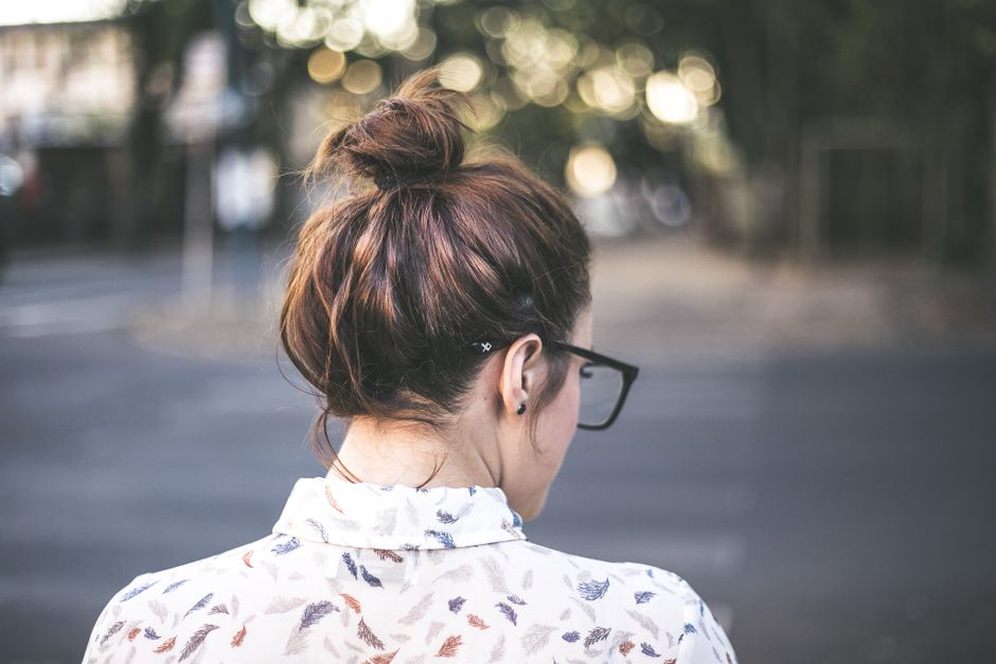 side view of a brunette with a resin and crystal barrette securing a chignon