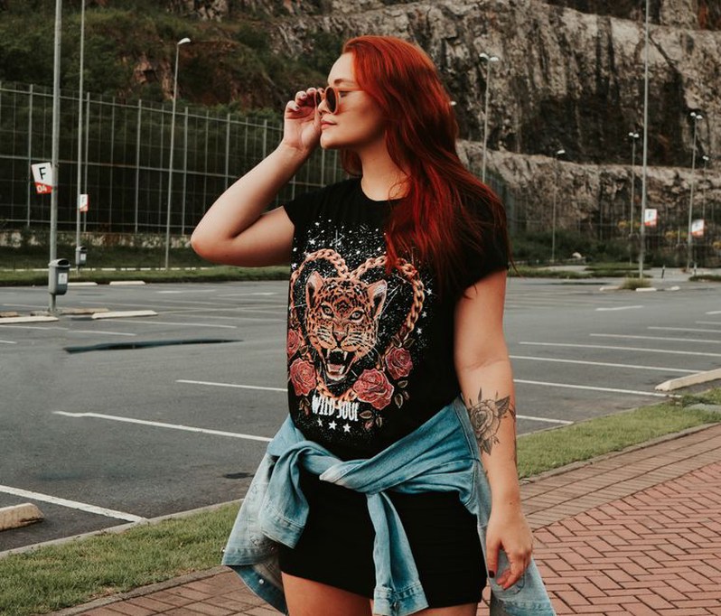 A woman in a white graphic T-shirt styled with colourful vintage hair clips in a half-up hairstyle