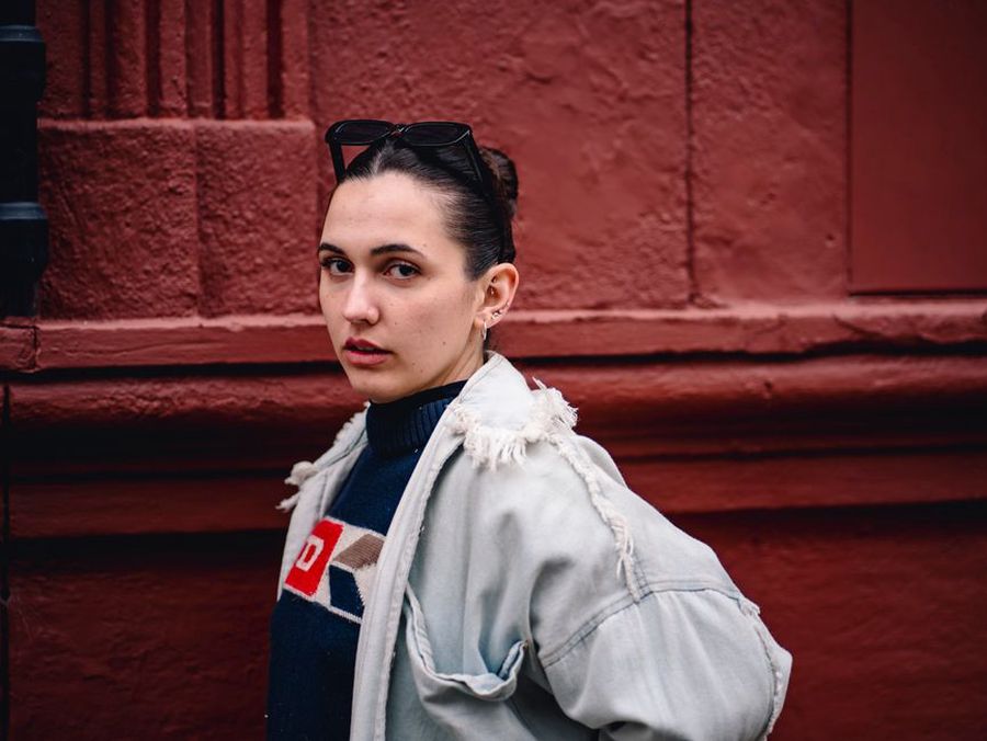 A brunette in a classic tweed jacket with the Sukie Yuki red clip securing a side section