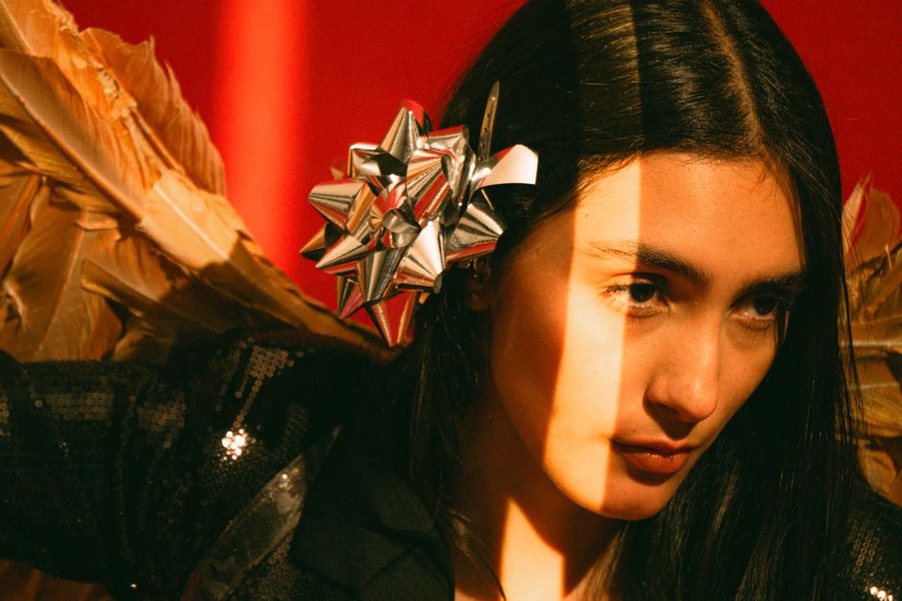 Side-swept brunette hair secured with a red pearl bow barrette