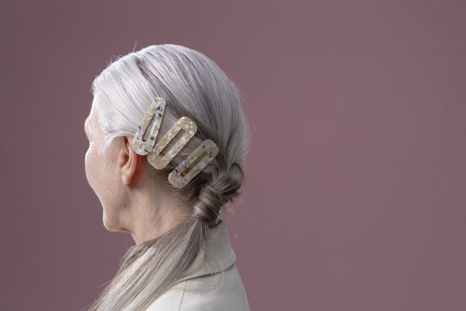 bakelite barrette clipped in a low bun with a modern linen jacket