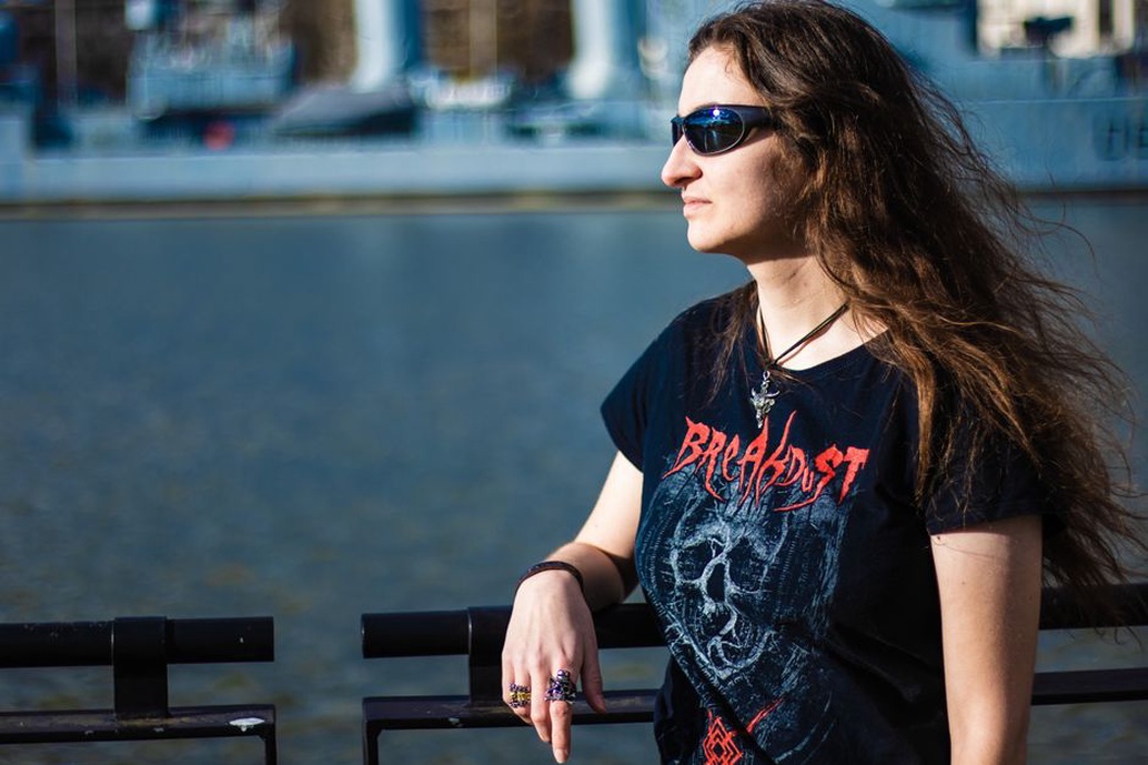 Woman in a faded band t-shirt with a tortoiseshell claw clip holding a half-up style