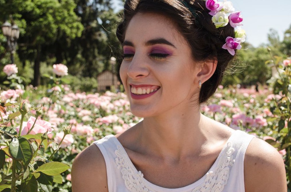 Woman in a white blouse with a blue silk rose crown headband over a short bob