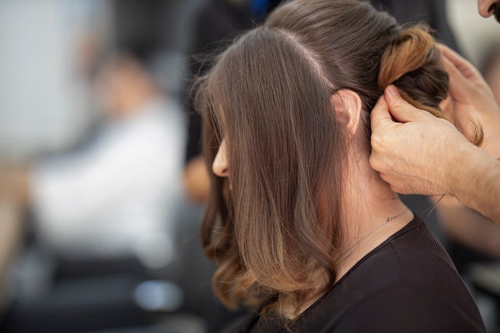 Midnight blue hair claw being placed into a low chignon