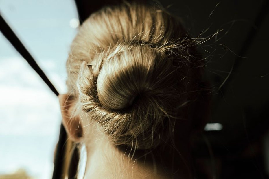 Golden Arizona bow barrette securing a side bun on a model in casual linen outfit