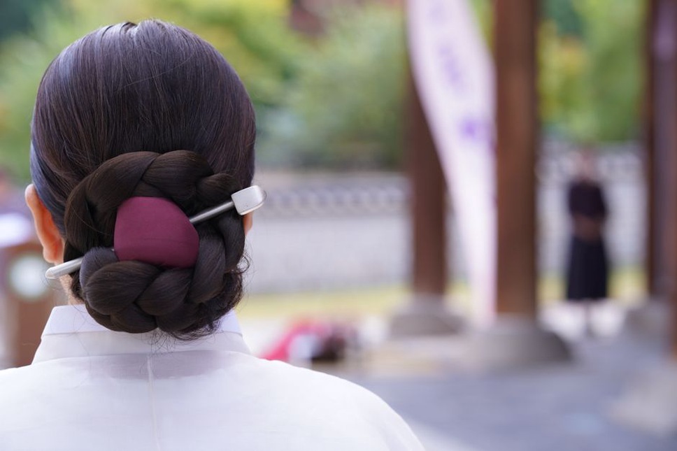 low chignon pinned with a vintage shell hairpin at a garden party
