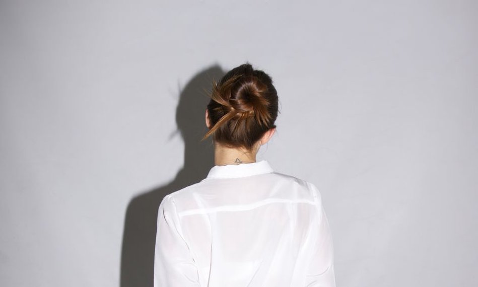 A woman wearing a mother of pearl claw clip in a casual updo