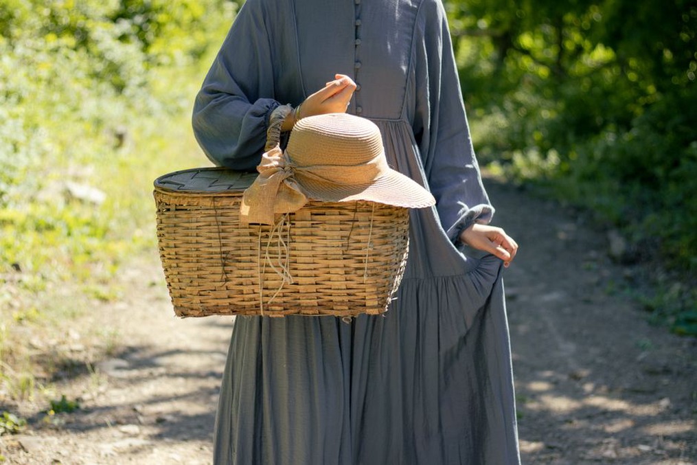 An outdoor portrait showing a straw hat and a matching rattan basket hair clip